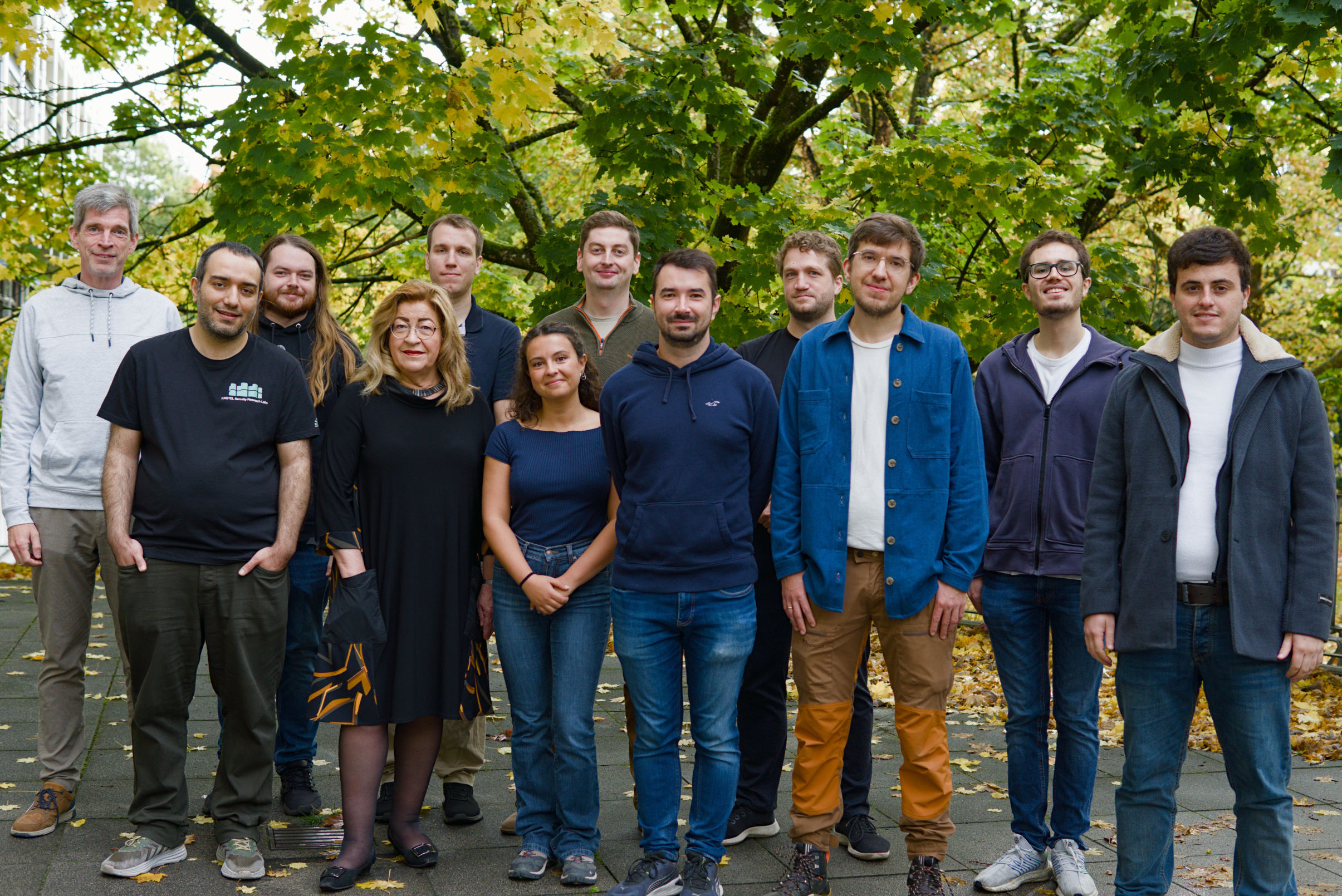 Group picture of the team in front of a tree in autumn
